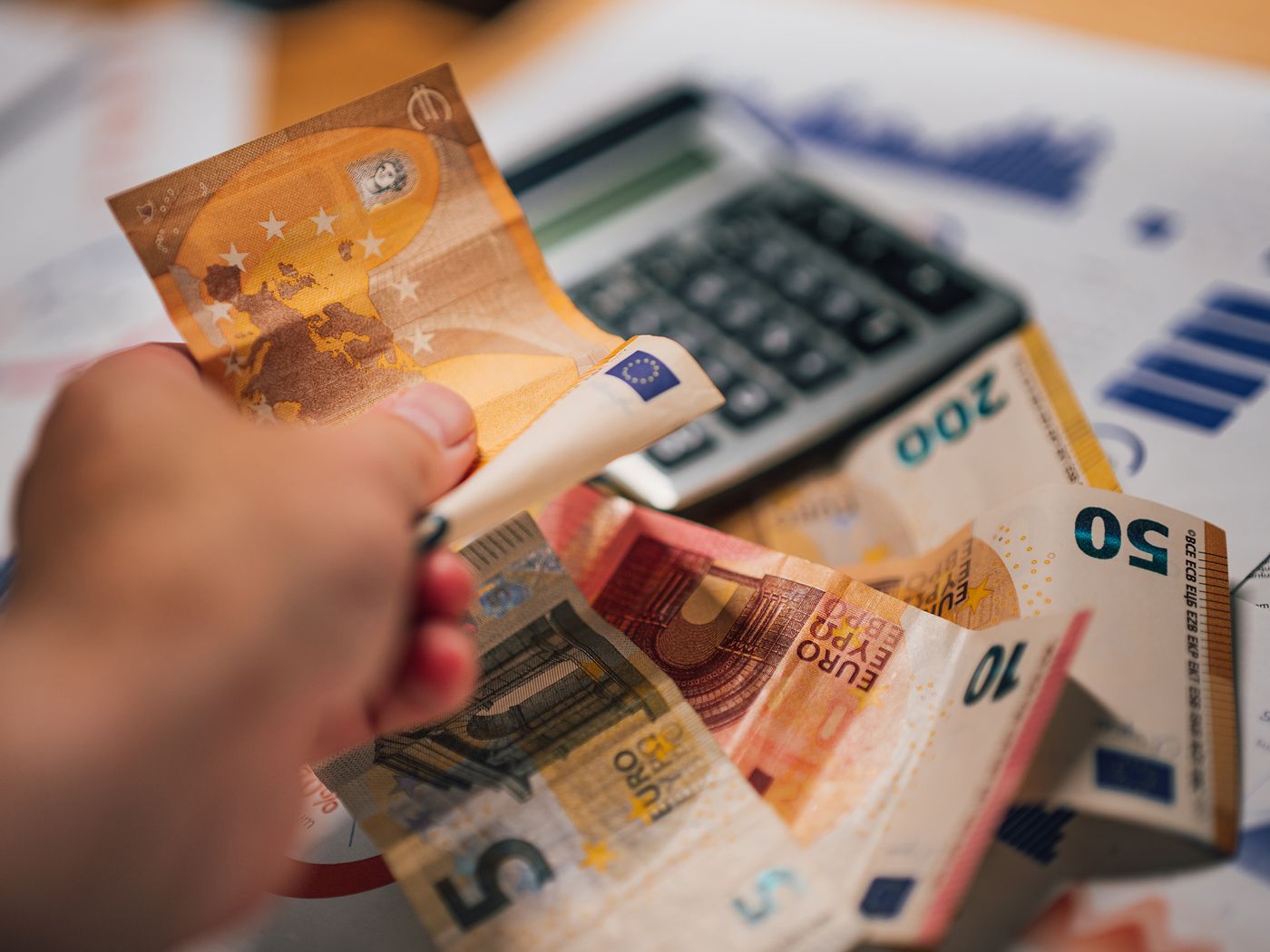Bancnote și calculator peste documente — calculul sumei asigurate